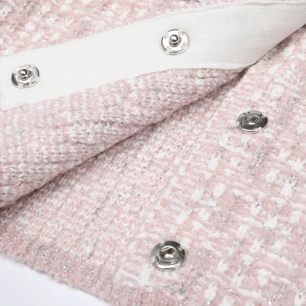 Close-up of pink textured fabric with silver buttons