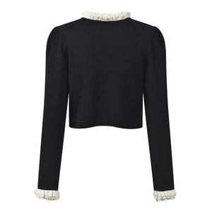 Black long-sleeve top with white ruffled collar and cuffs on a white background