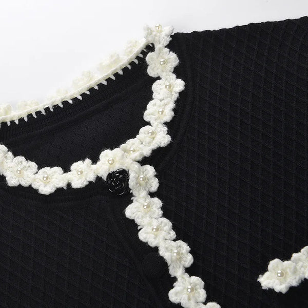 Black garment with white floral lace trim on a white background