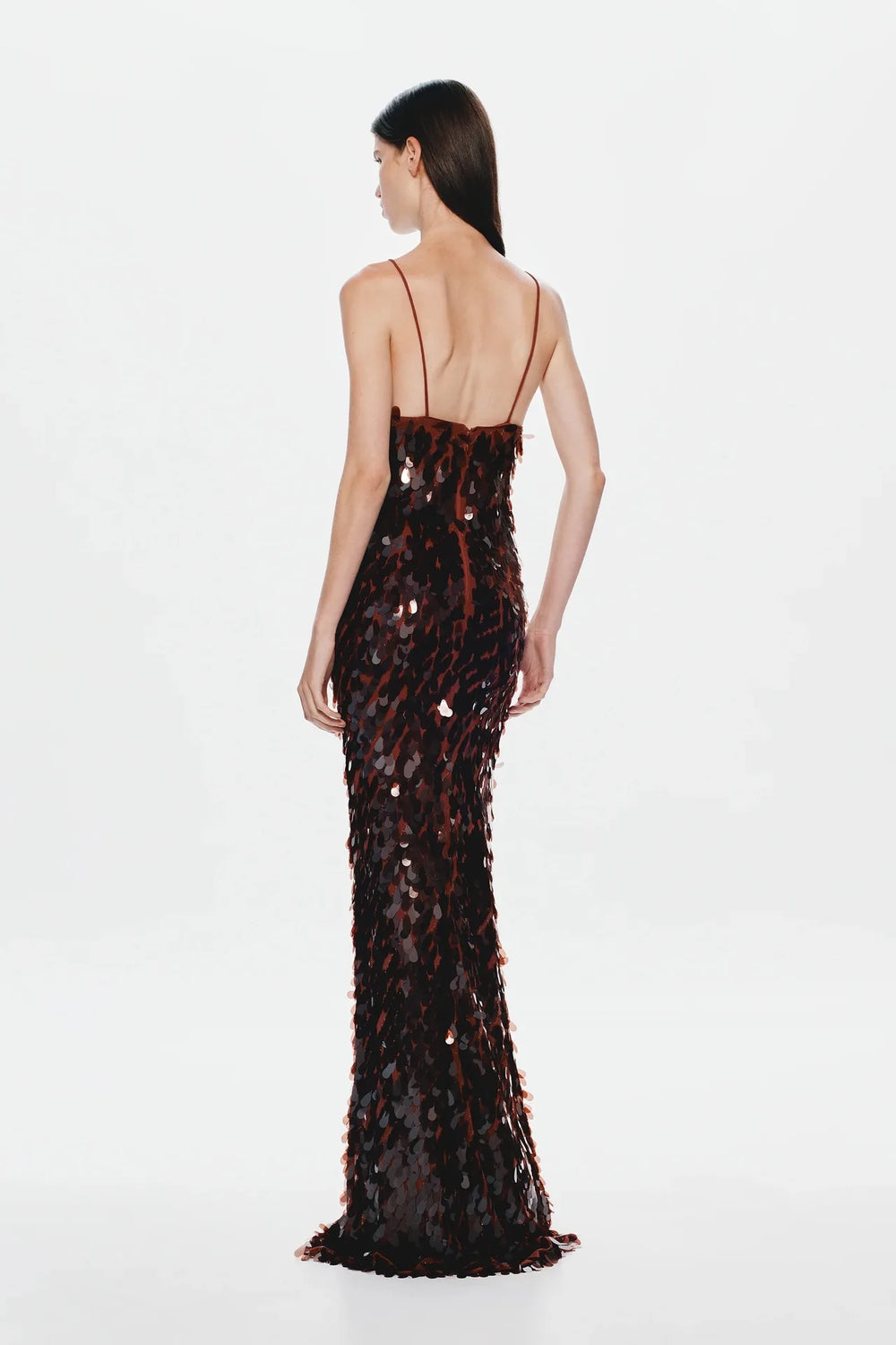Woman wearing a black sequin evening gown on a white background
