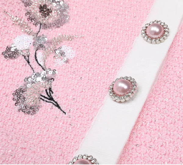 Pink fabric with floral embellishments and a white ribbon