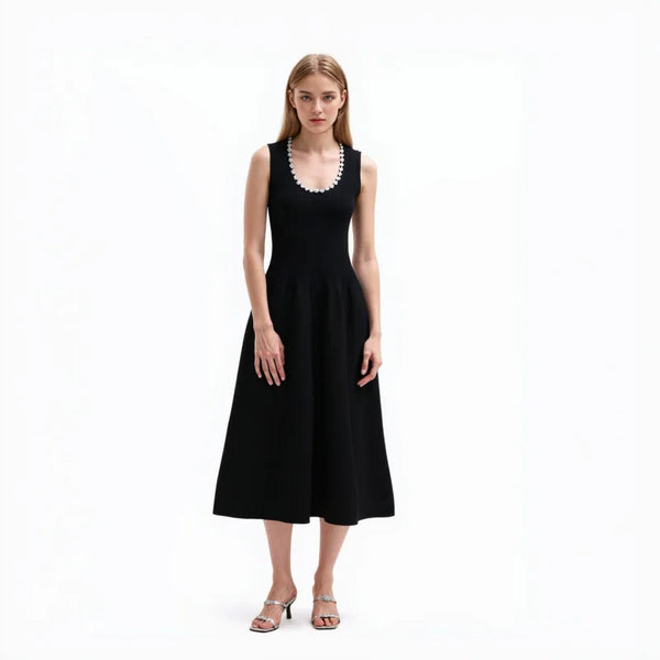 Woman wearing a black sleeveless dress with a white collar on a white background