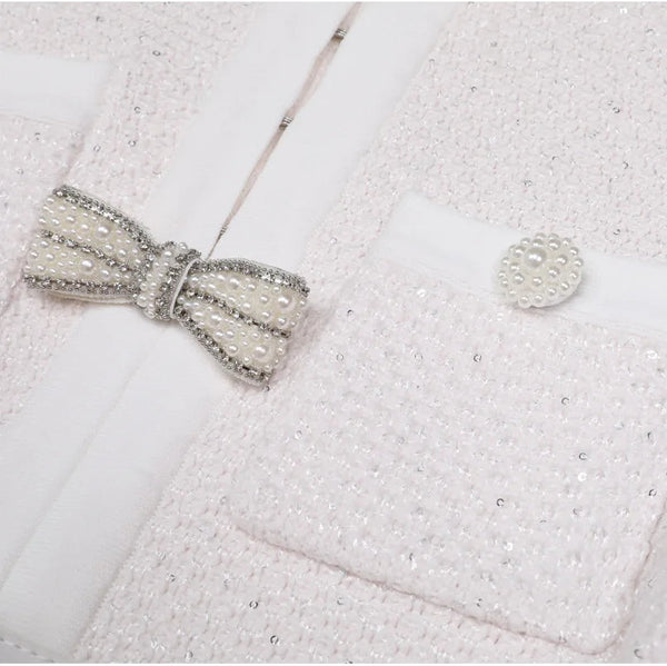 Close-up of a textured white fabric with a decorative bow and button.