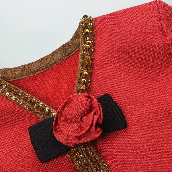 Red garment with gold trim and a black bow on a light gray background