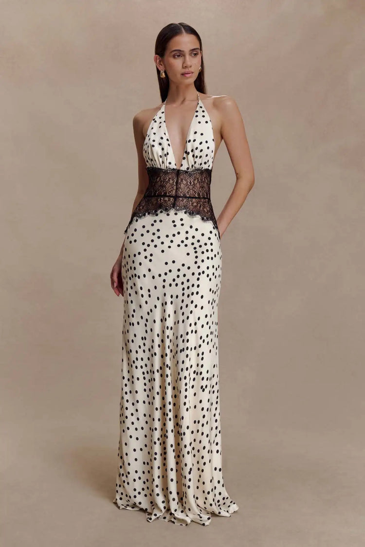 Woman wearing a polka dot dress with a lace bodice on a beige background