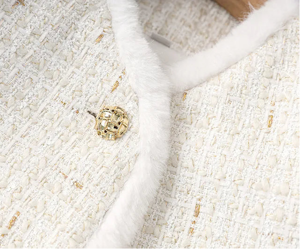 Close-up of a textured white fabric with a gold button
