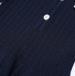 Navy blue cardigan with white floral embellishments on a white background