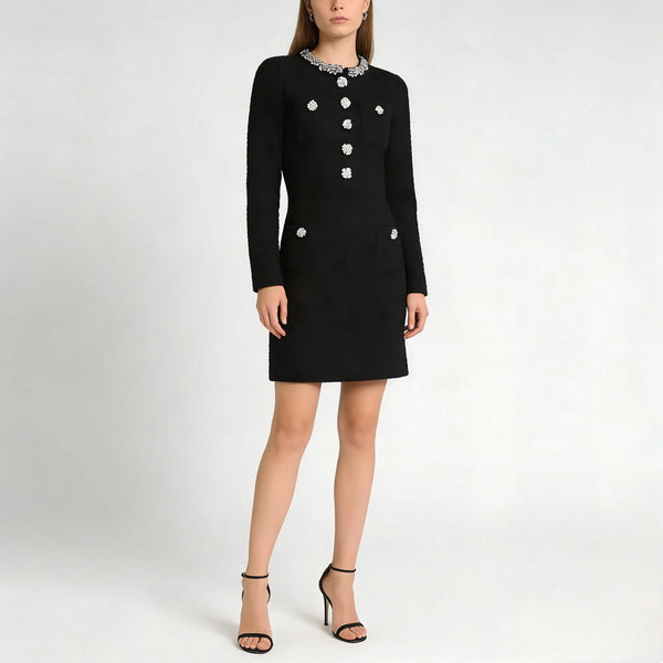 Black dress with white buttons worn by a model on a white background