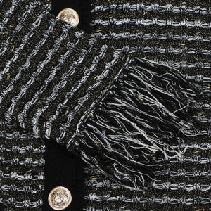 Close-up of a textured black fabric with intricate patterns and a button.