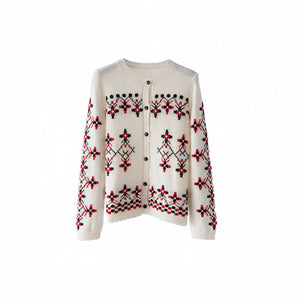 White sweater with red and black patterns on a wooden hanger against a white background