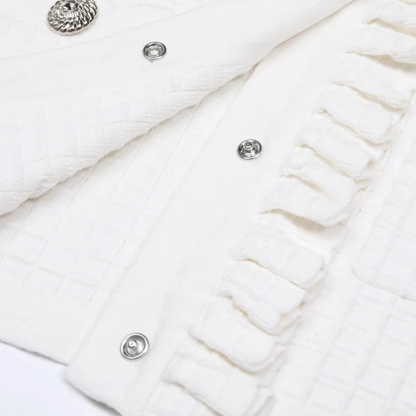 Close-up of a white textured fabric with buttons on a light background