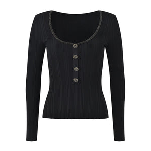 Black long-sleeve top with decorative buttons on a white background