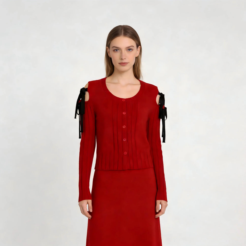 Red sweater with black ribbons on shoulders against a white background