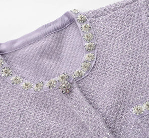 Lavender top with floral embellishments on a white background