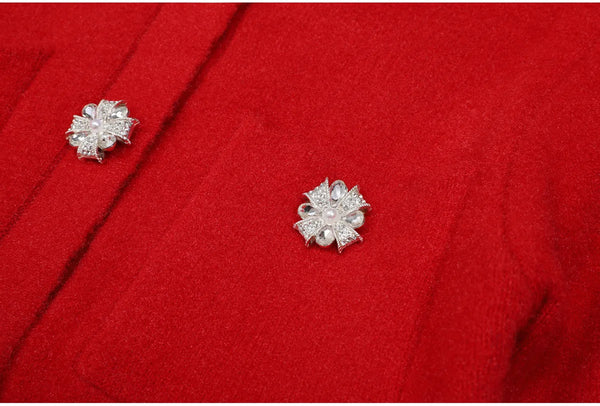 Silver floral earrings on a red fabric background