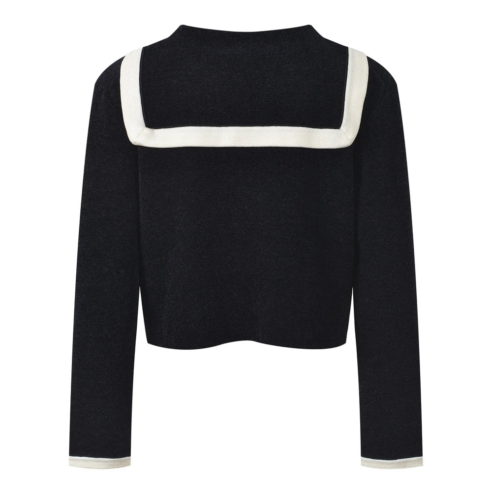 Black cardigan with white trim and buttons on a white background