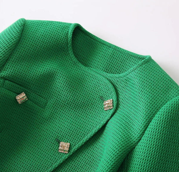 Green knitted cardigan with button details on a light gray background