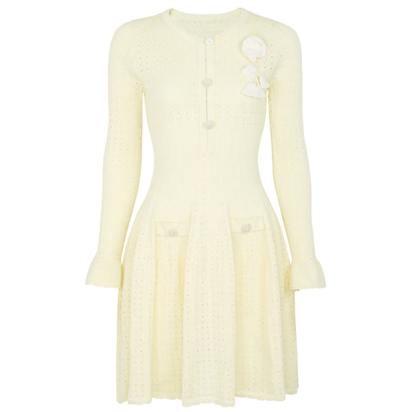 Light yellow dress with long sleeves and a floral brooch on a white background