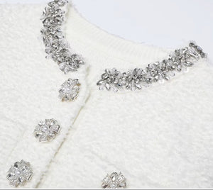 Silver jewelry set with necklace and earrings on a white textured background