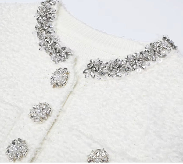 Silver jewelry set with necklace and earrings on a white textured background