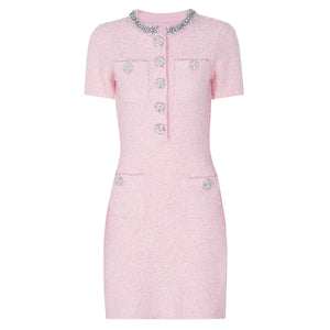 Pink dress with decorative buttons on a white background