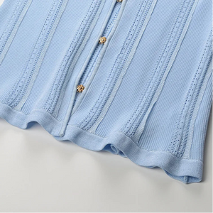 Close-up of a light blue ribbed fabric with buttons on a white background