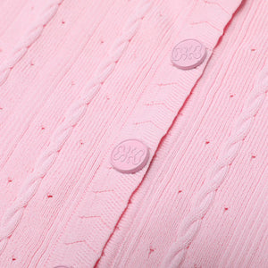 Close-up of a pink textured fabric with buttons, featuring the brand 'Cotter' on a pink background.