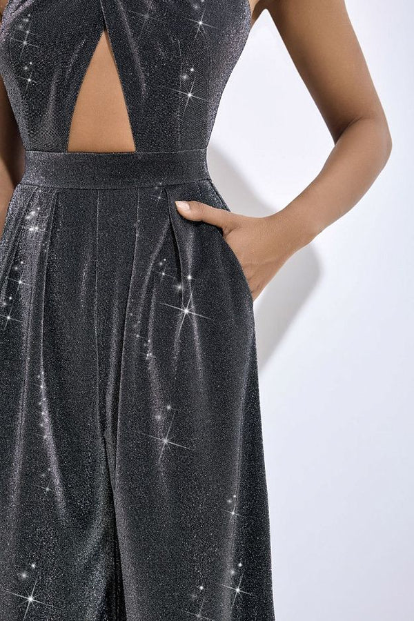 Close-up of a model wearing a dark gray glitter jumpsuit with a cutout at the chest and pockets, featuring a sparkling star pattern.