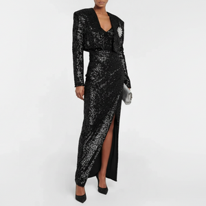 Black sequin dress with long sleeves and a slit on a white background