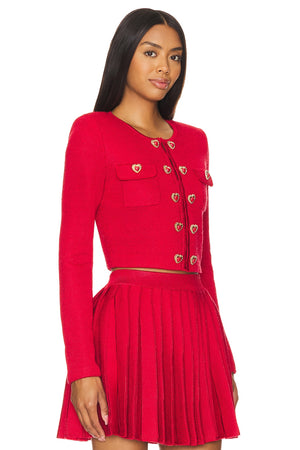 Woman wearing a red outfit with heart buttons on a white background