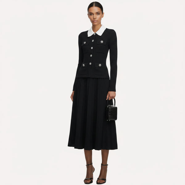 Woman wearing a black outfit with a white collar, holding a black handbag on a white background