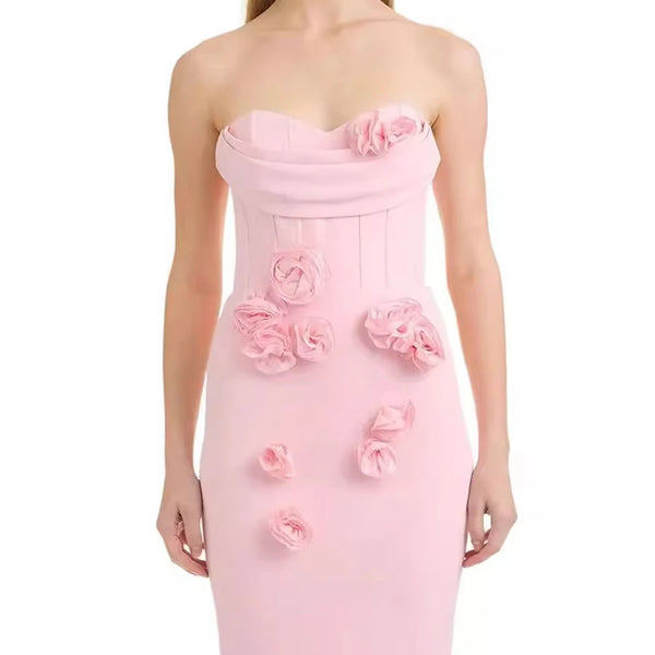 Pink strapless dress with floral embellishments on a white background