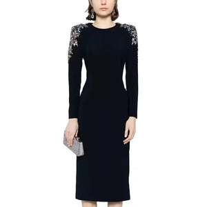 Black dress with floral embellishments on shoulders against a white background