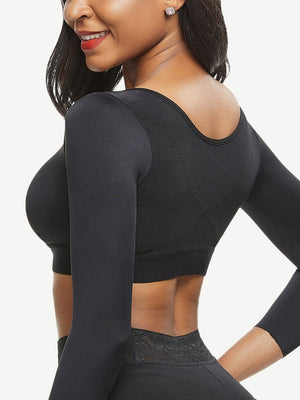 Woman wearing a black long-sleeve athletic top and leggings on a white background