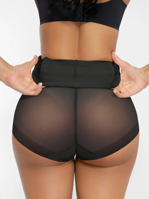 Person wearing sheer black shorts with a plain background