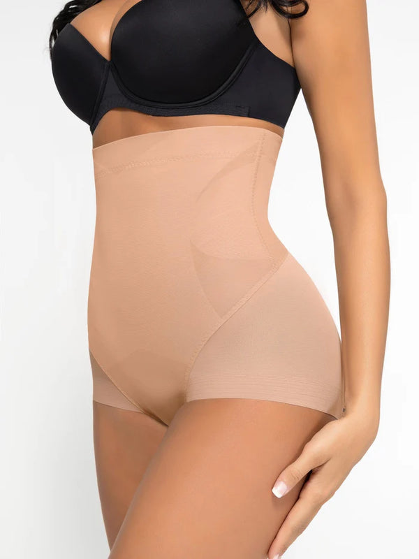 Woman wearing a black bra and beige shapewear on a white background