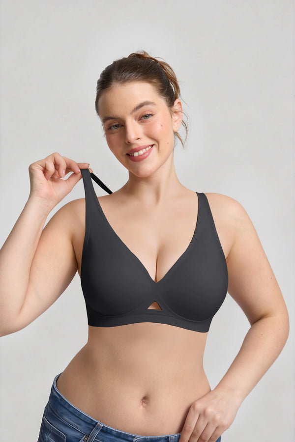 Woman wearing a black bra against a plain background