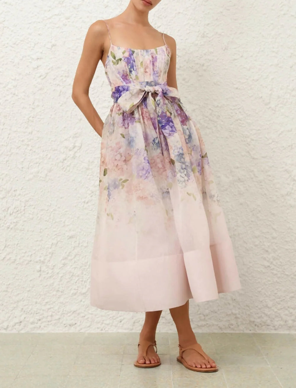 Woman wearing a floral dress with a white textured wall background